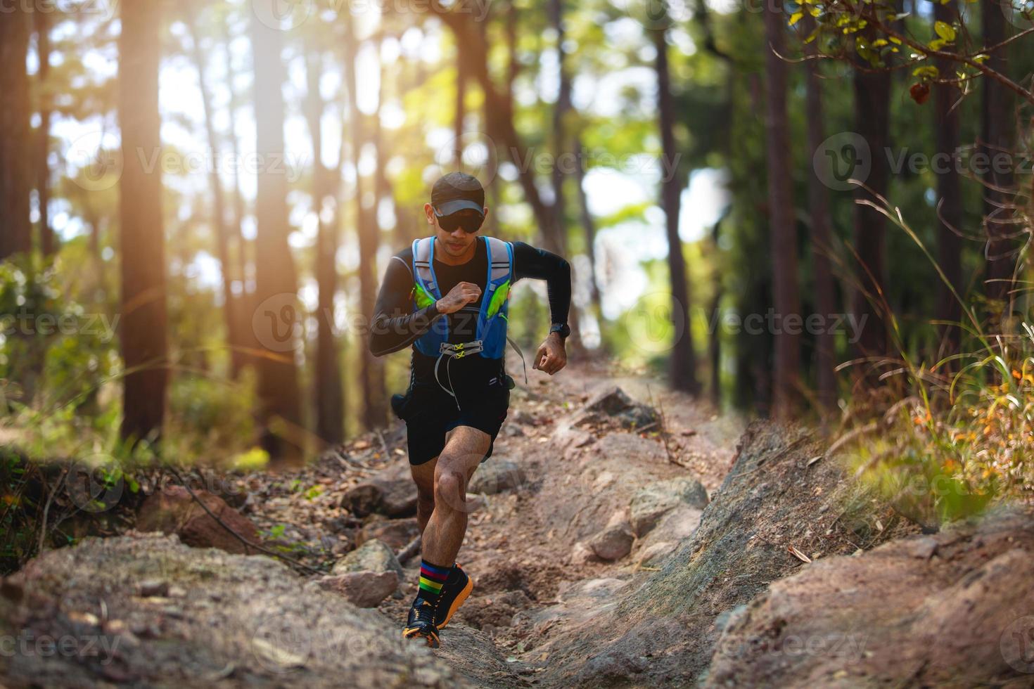 ein Mann Läufer der Spur. und die Füße des Athleten, die Sportschuhe für Trailrunning im Wald tragen foto