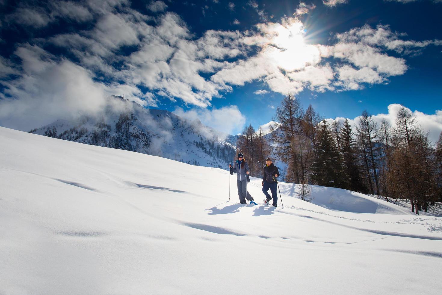 Schneeschuhwandern in den Bergen eines Paares foto