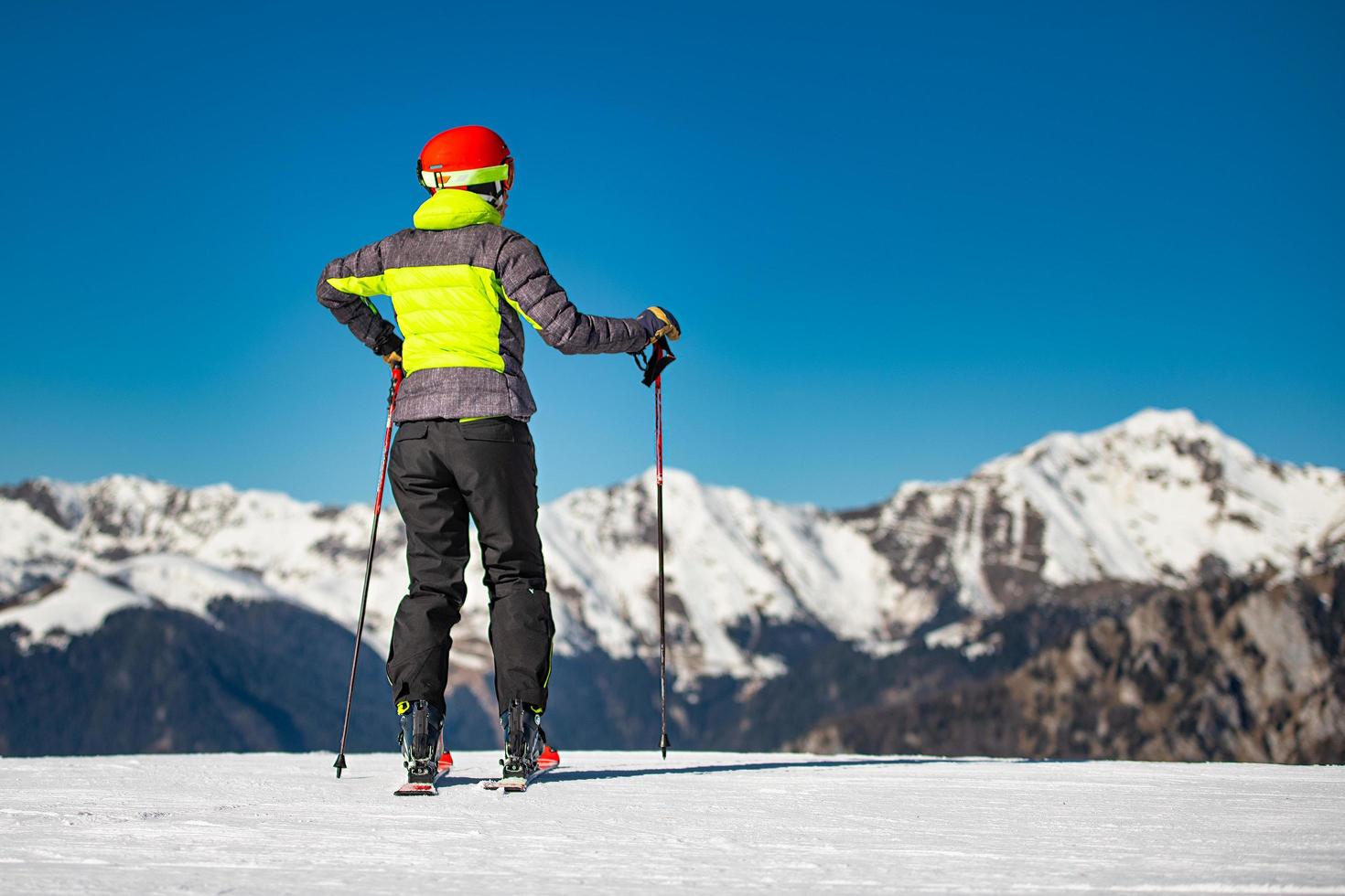 Auf den Skipisten eines Skigebiets blickt ein Skifahrer vor dem Skifahren auf die Berge foto