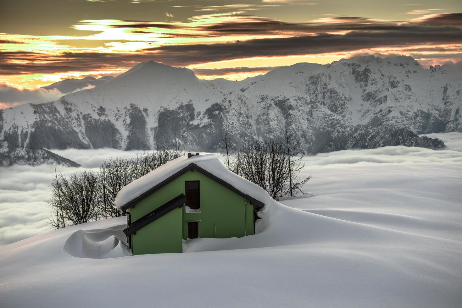 Almhütte im Schnee bei Sonnenuntergang foto