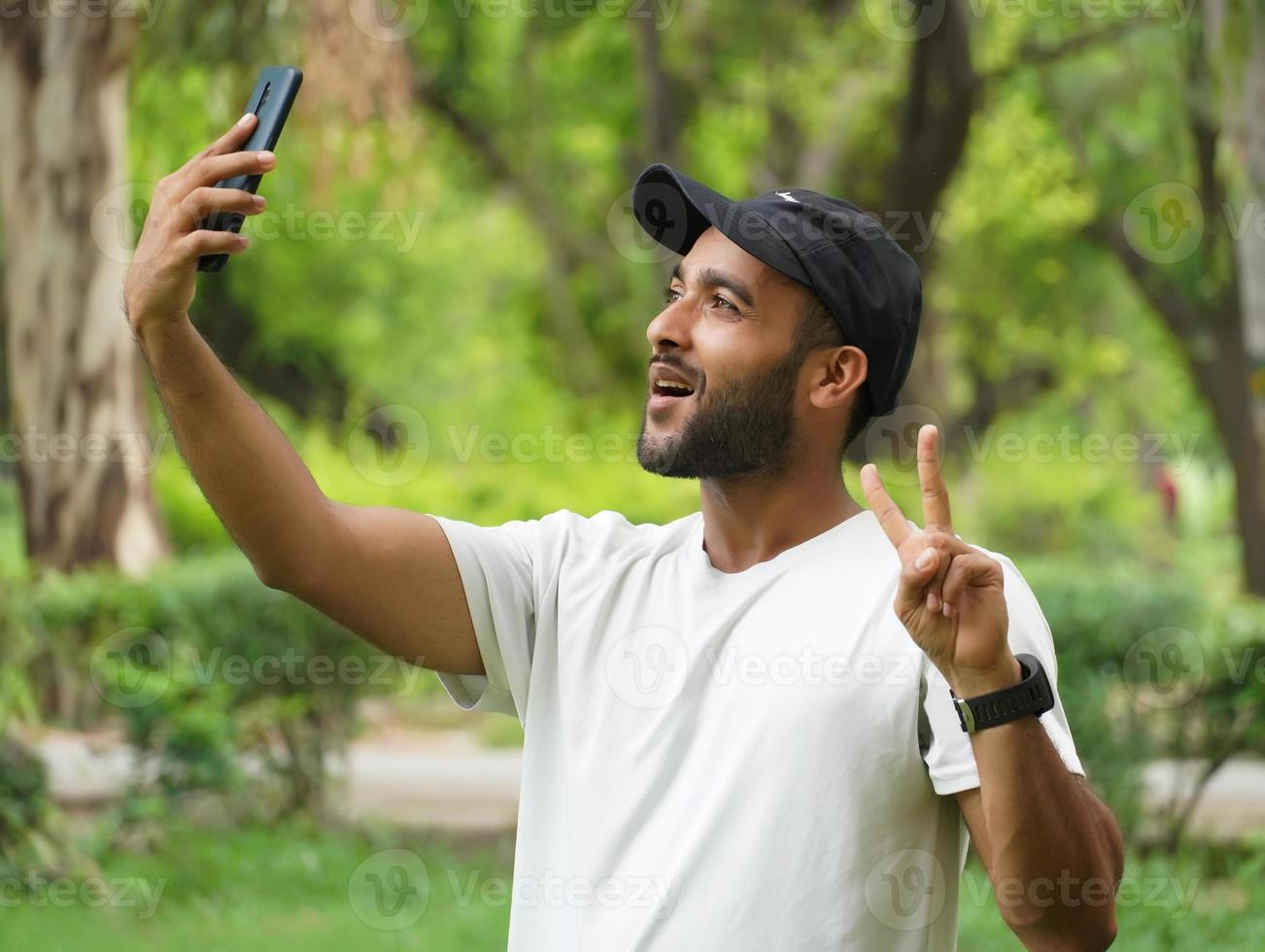 selfie mit handy machen und siegeszeichen zeigen foto
