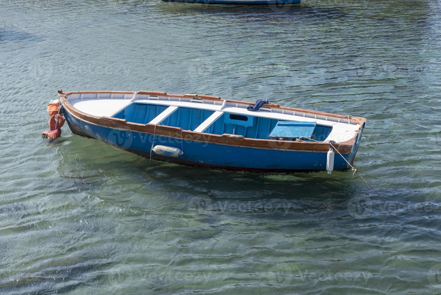 Altes Holzboot am Pier in klarem Wasser. foto