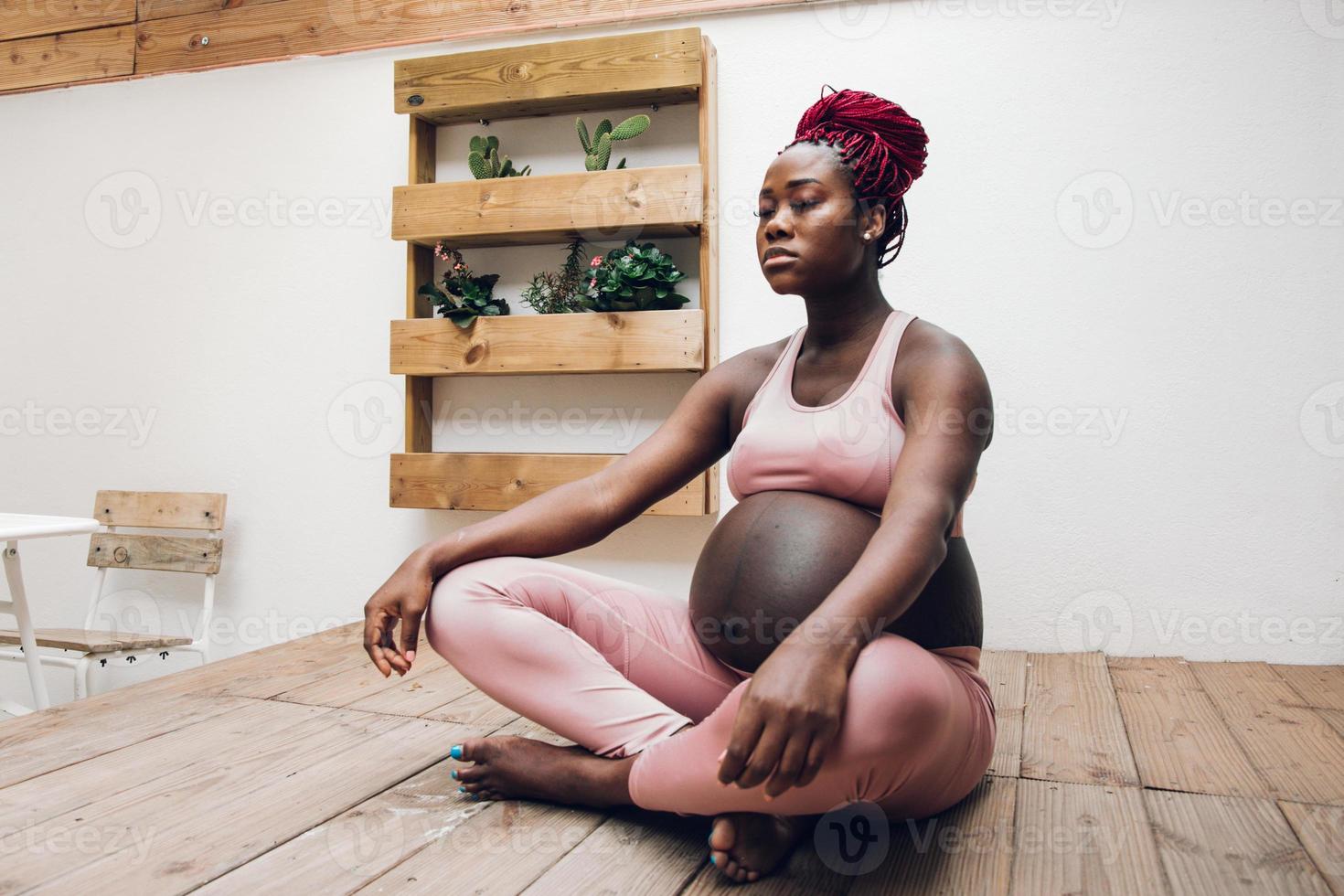 schwarze schwangere frau, die etwas ioga und meditation tut foto