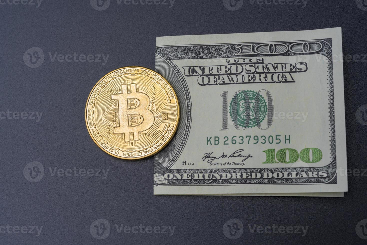 hundert Dollar und Bitcoin auf schwarzem Hintergrund. foto