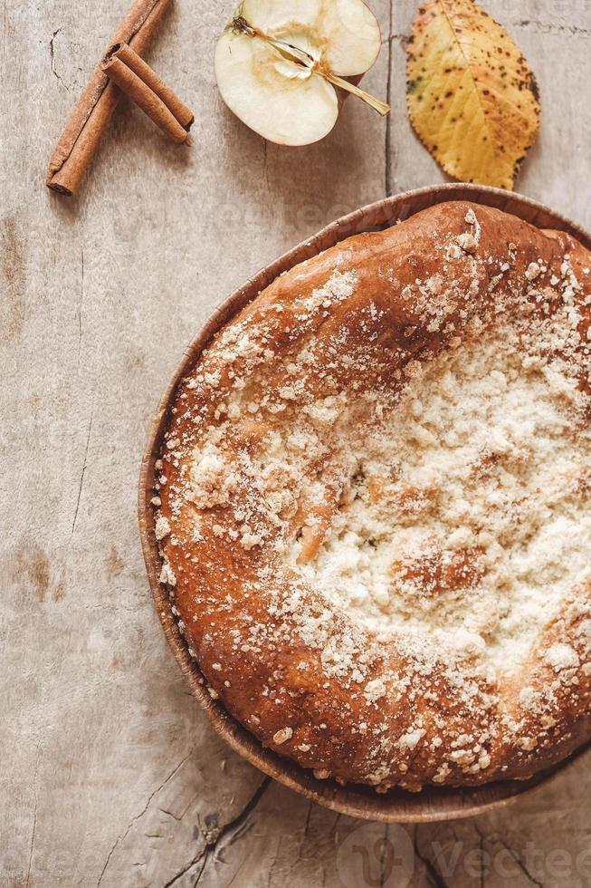 hausgemachter Apfelkuchen und Zimt auf Vintage-Holzhintergrundtextur. Ansicht von oben. kopieren, leerer platz für text foto