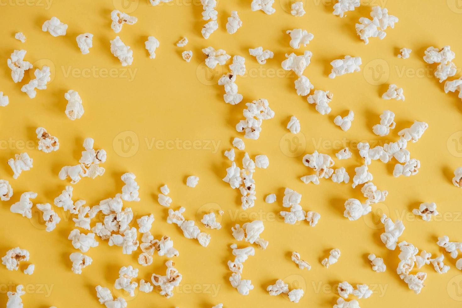 Popcorn auf gelbem Hintergrund als Hintergrundbild. Ansicht von oben. kopieren, leerer platz für text foto