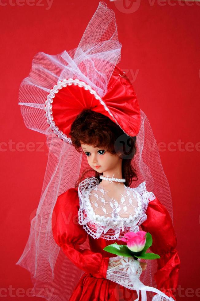 anmutiger Look einer Puppe im roten Brautoutfit foto