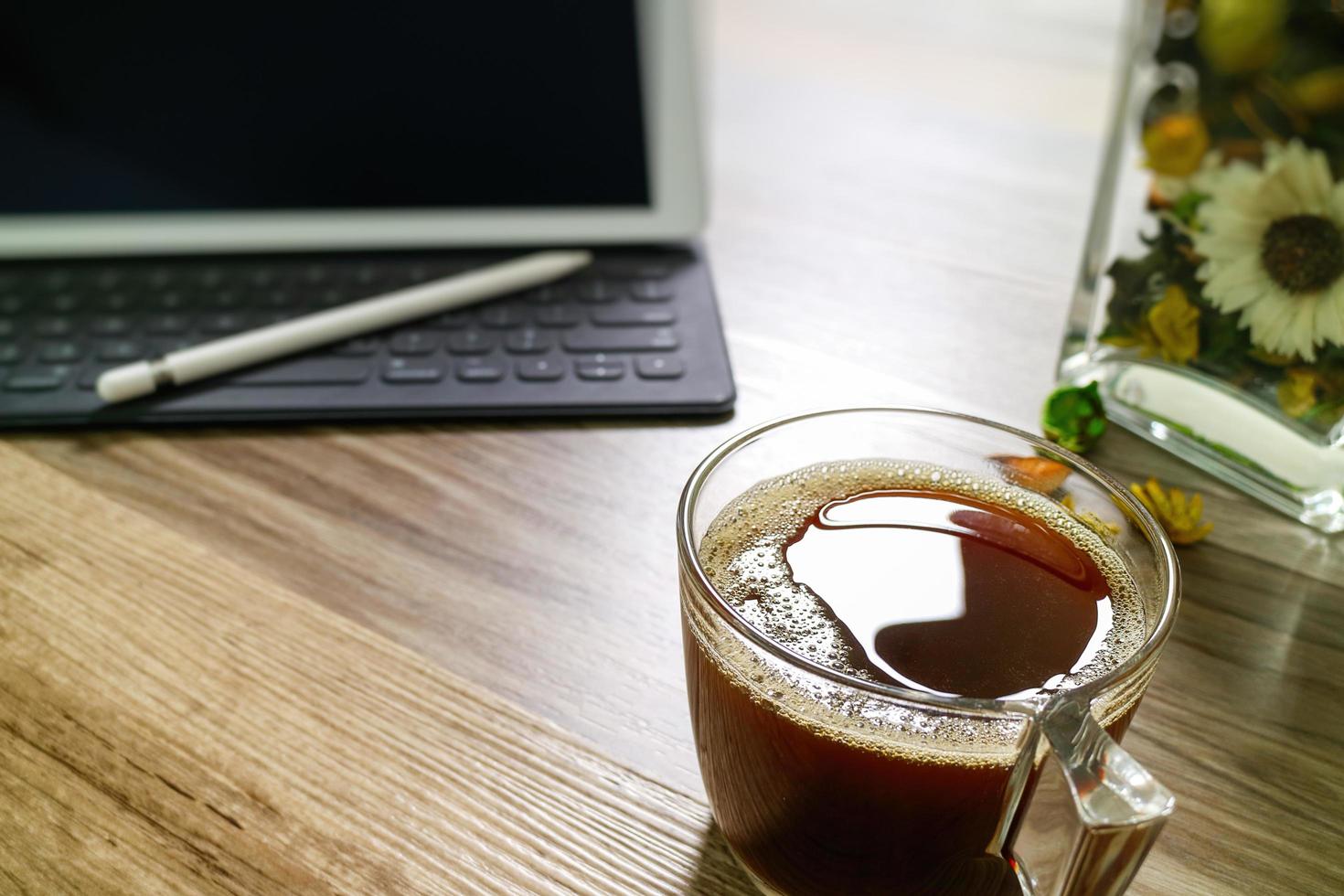 kaffeetasse oder tee und digitaler tisch dock intelligente tastatur, vase blumenkräuter, stift auf holztisch, filtereffekt foto