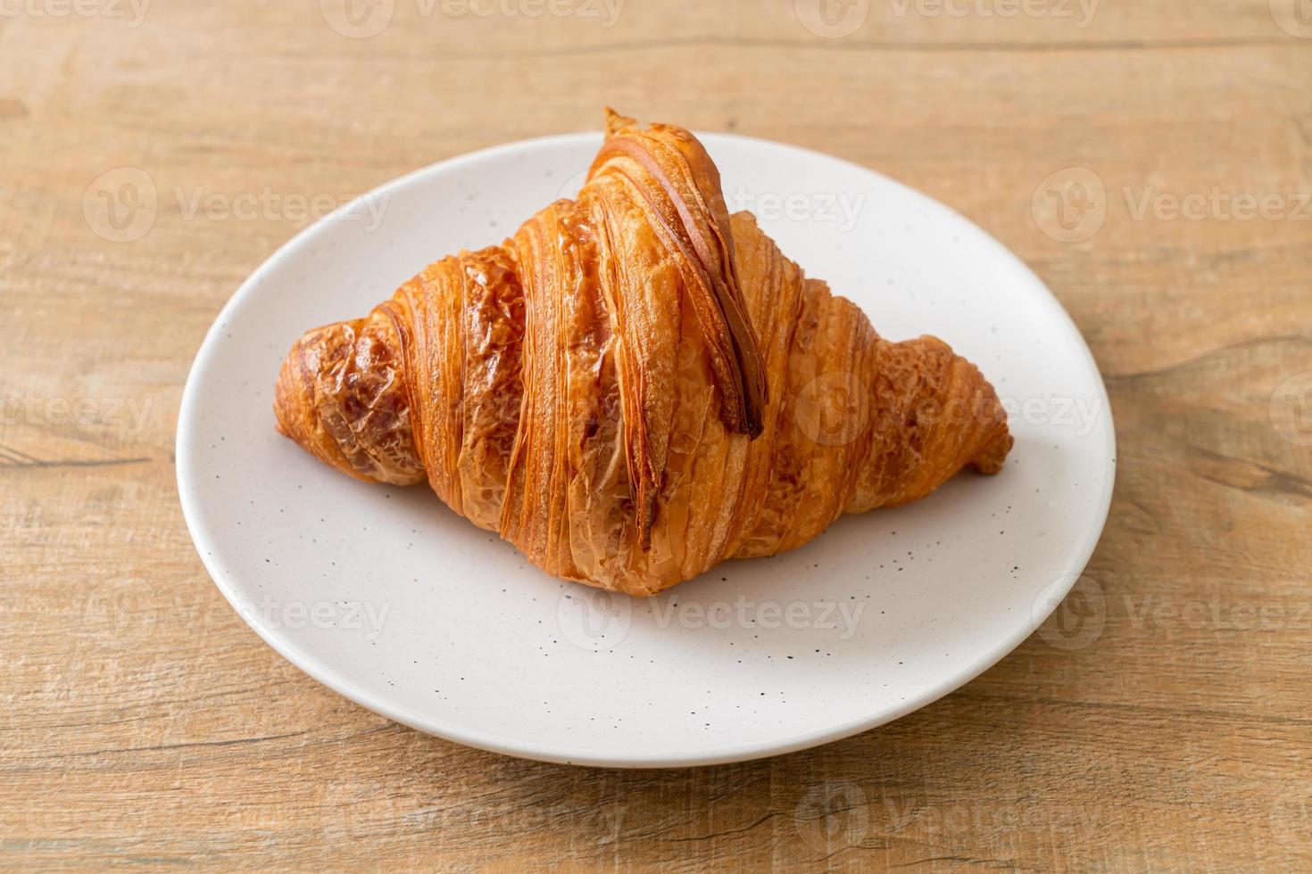 frisches Croissant auf weißer Platte foto