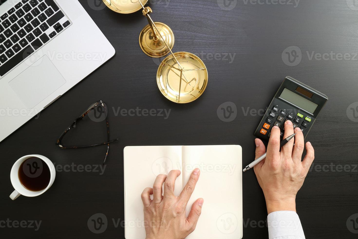 justiz- und rechtskonzept. geschäftsmann oder rechtsanwalt oder buchhalter, der mit einem taschenrechner und einem laptop und dokumenten in einem modernen büro an rechnungen arbeitet foto