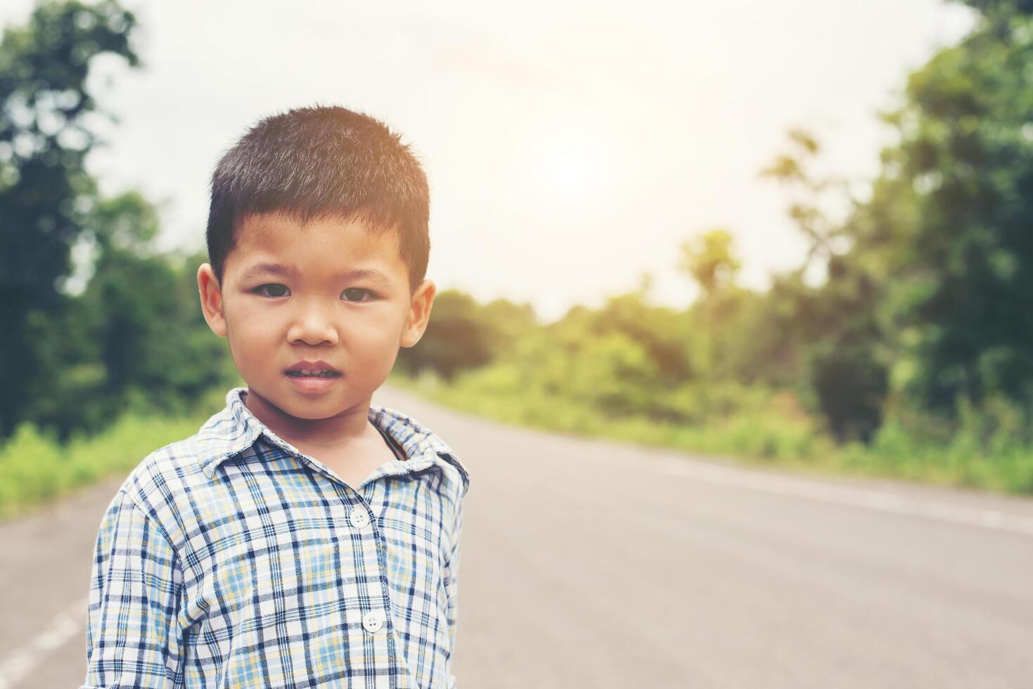Porträt eines kleinen süßen asiatischen Jungen im Park, der in die Kamera lächelt. foto