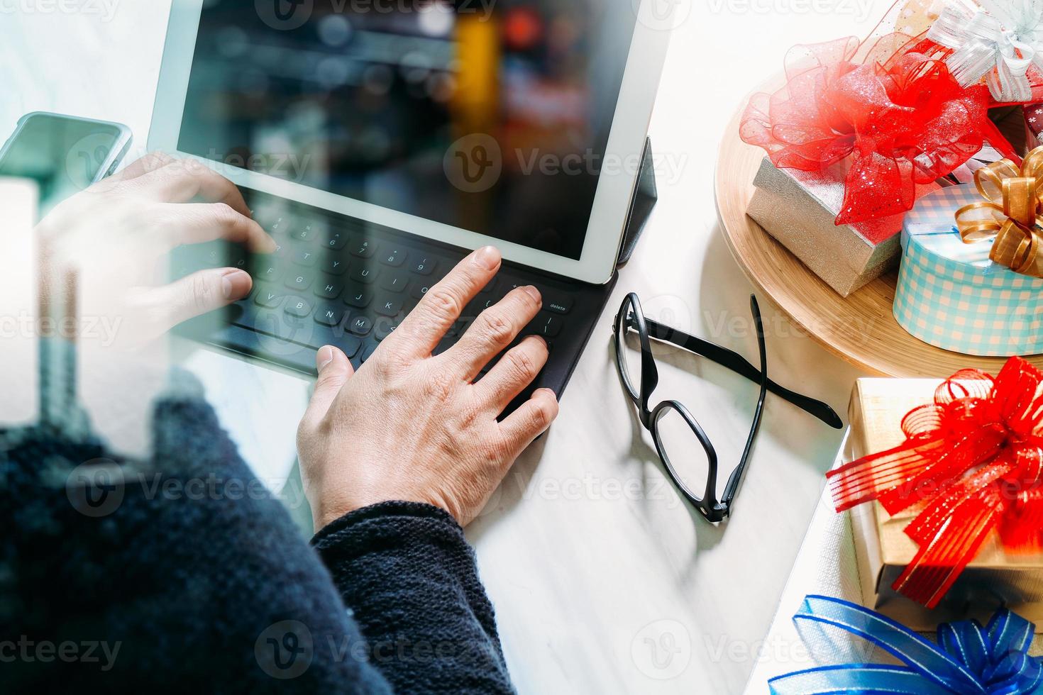 geschenk, das kreative hand mit eingabe und hand mit geschenk gibt. geschenklieferung, überraschung, tablet-computer, der intelligentes tastatur-smartphone auf mable-schreibtisch andockt, filterfilmeffekt foto