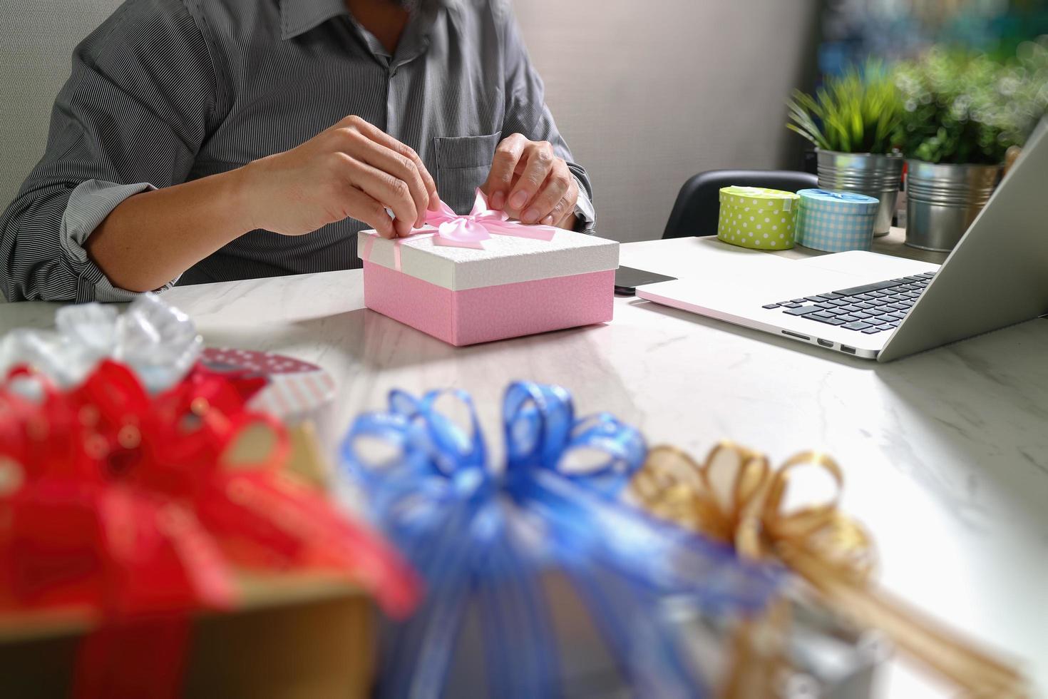 geschenk, das kreative handauswahl und hand mit geschenk gibt. geschenklieferung, überraschung, laptop und smartphone auf mable schreibtisch, filterfolieneffekt foto