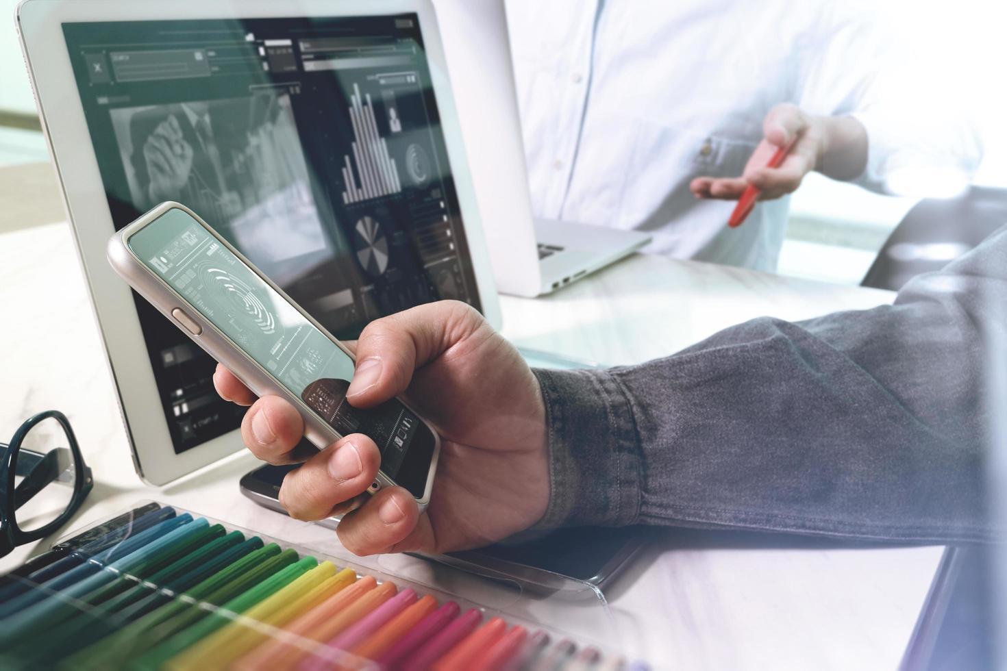 zwei kollegen webdesigner diskutieren daten und digitales tablet und computer laptop mit smartphone und designdiagramm auf marmorschreibtisch als konzept foto