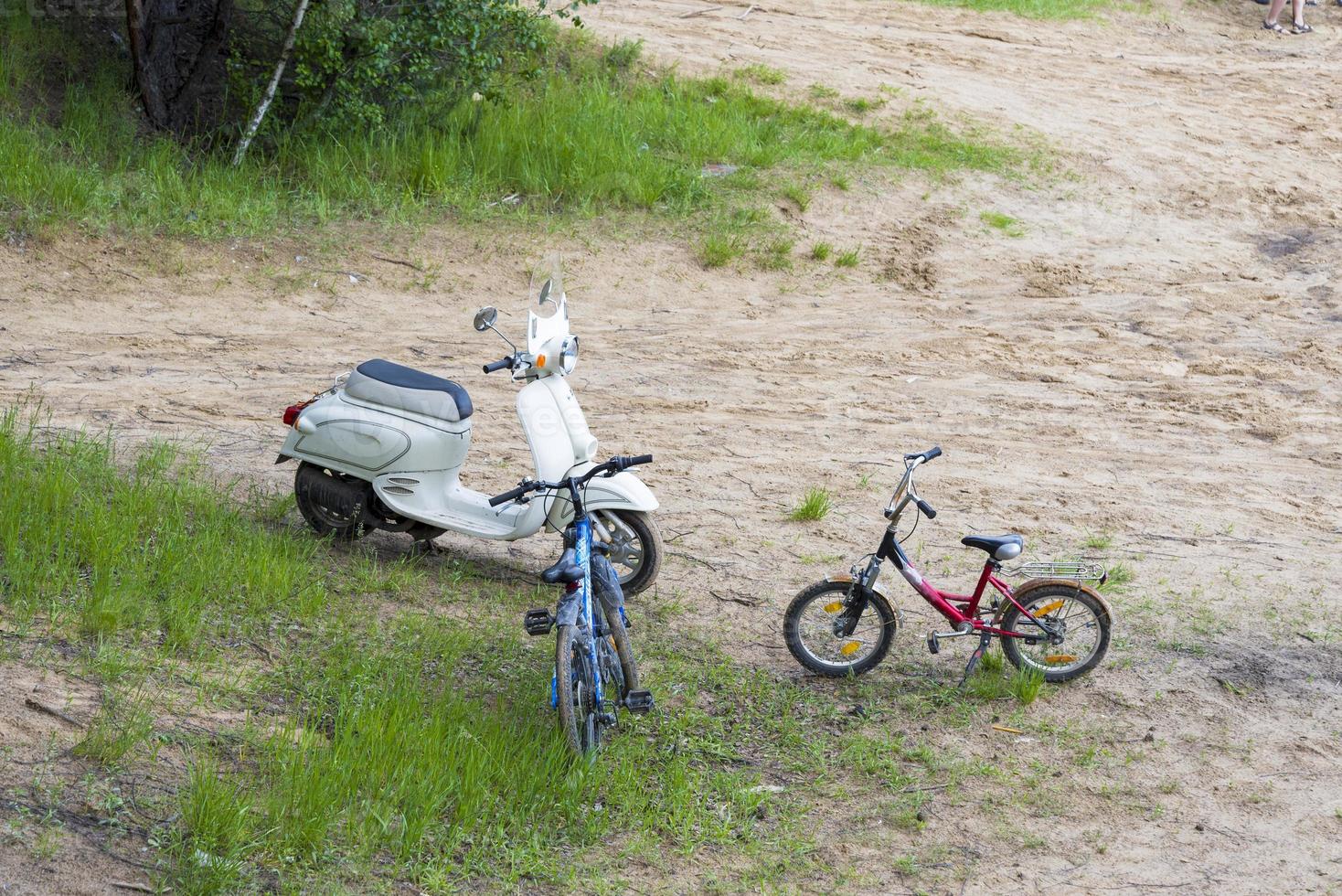 ein altes Oldtimer-Moped und zwei Fahrräder stehen im Sand. foto