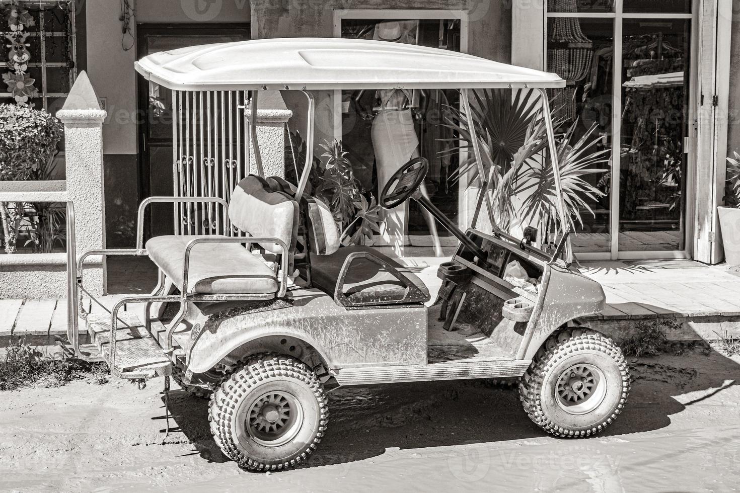 golfwagen buggy autos karren schlammige straße dorf holbox mexiko. foto