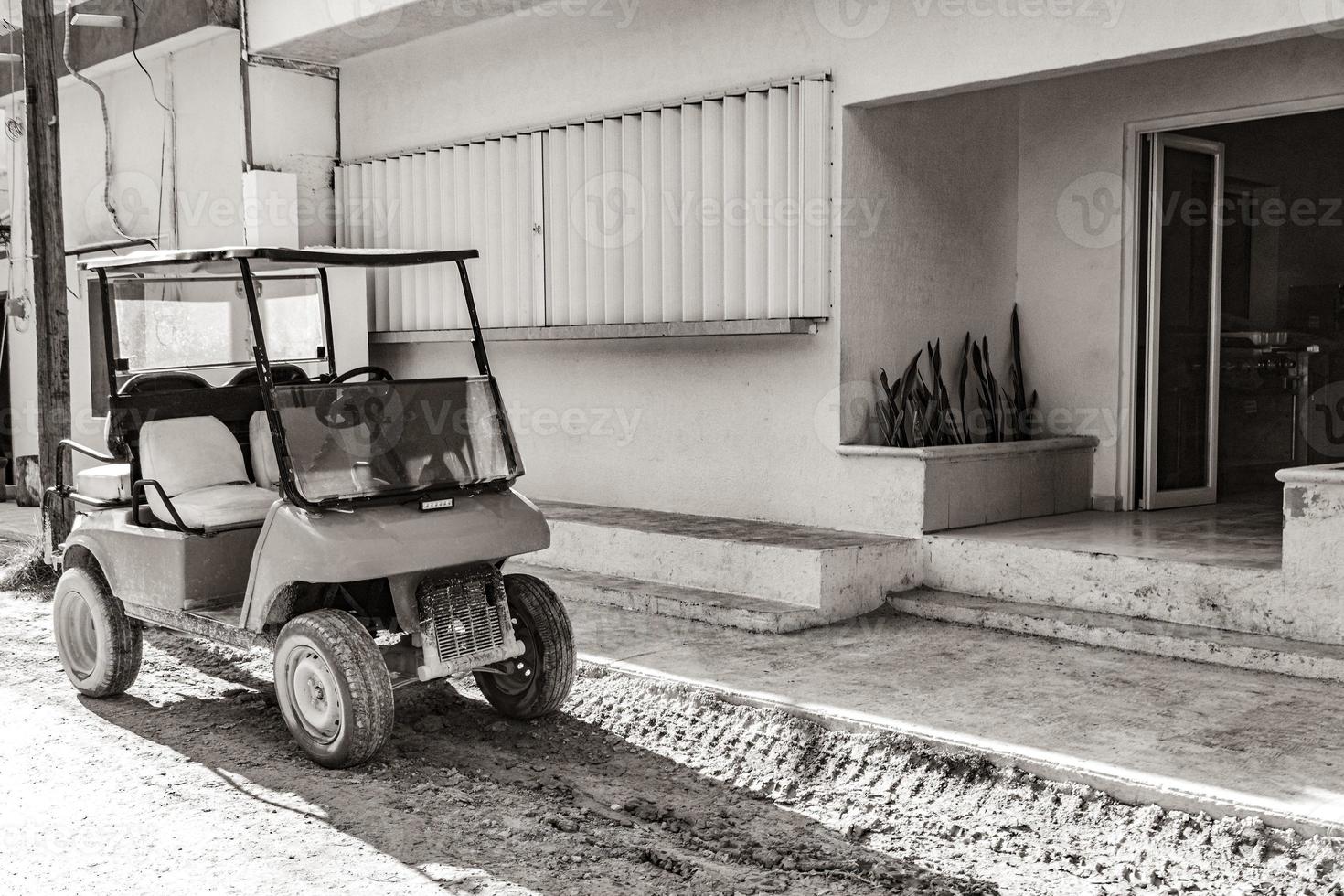 golfwagen buggy autos karren schlammige straße dorf holbox mexiko. foto