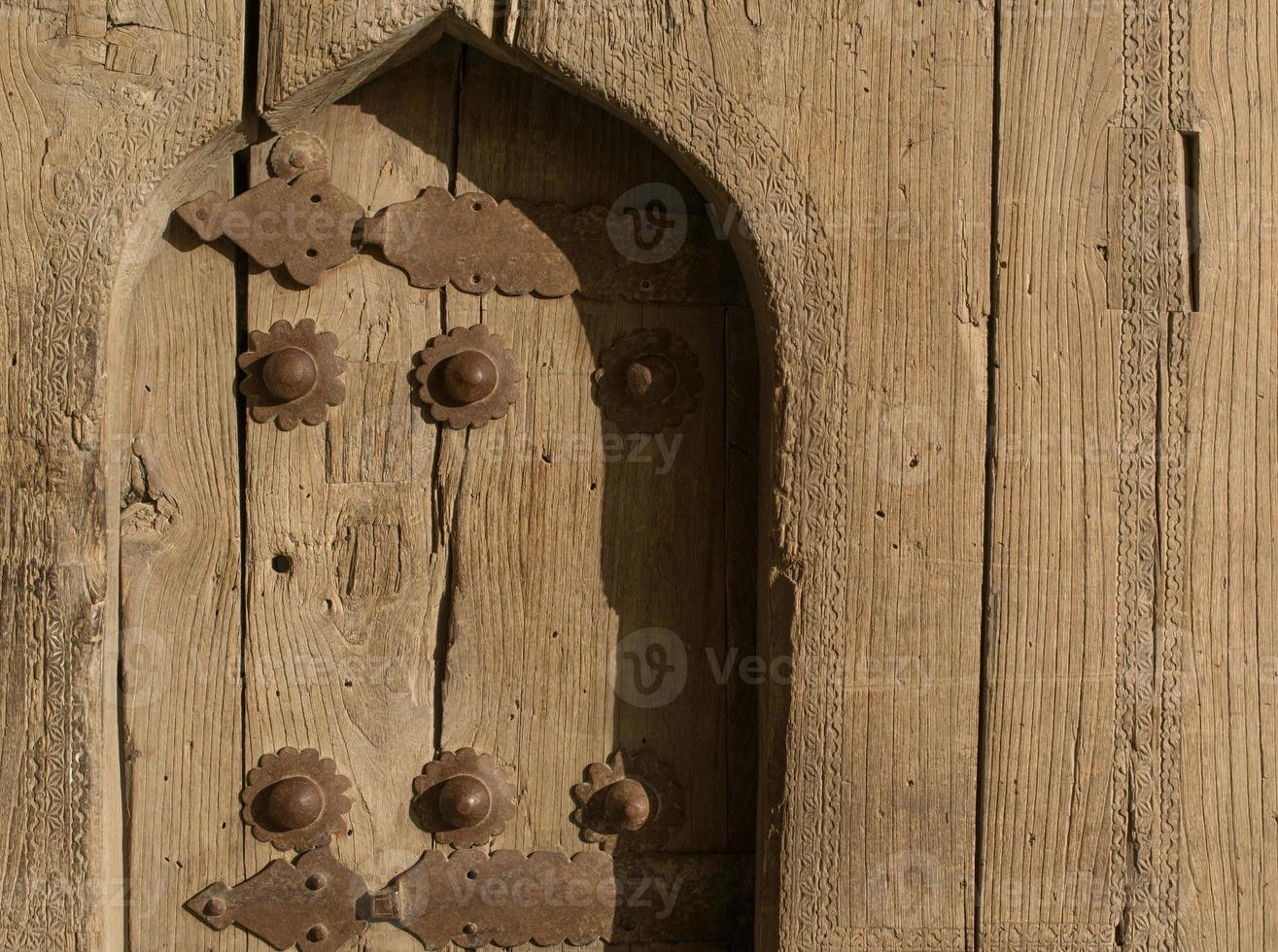 Alte Holztür mit Metallnieten in Buchara, Zentralasien. foto