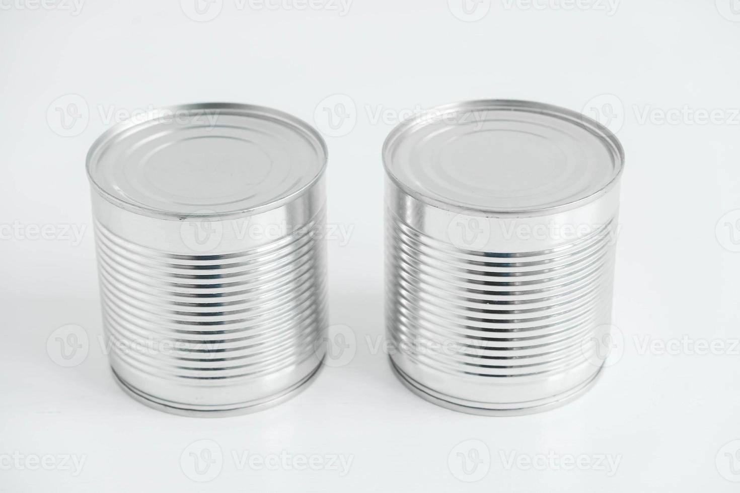 Zwei geschlossene Metalldosen aus Aluminium auf einem weißen Tisch. kopieren, leerer platz für text foto