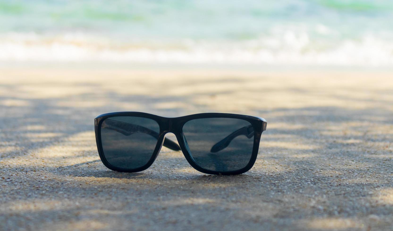 Sonnenbrille auf Sand schöner Sommerstrand foto