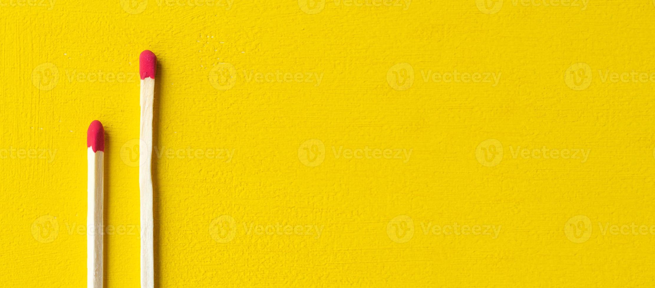 Zwei auf gelbem Hintergrund isolierte Streichhölzer schließen sich mit einem Leerzeichen für Ihren Text foto