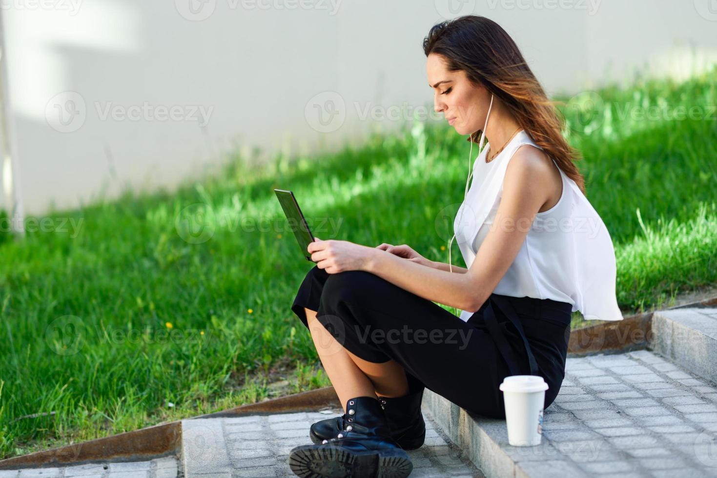 Geschäftsfrau mittleren Alters, die mit ihrem Laptop arbeitet und auf dem Boden sitzt. foto