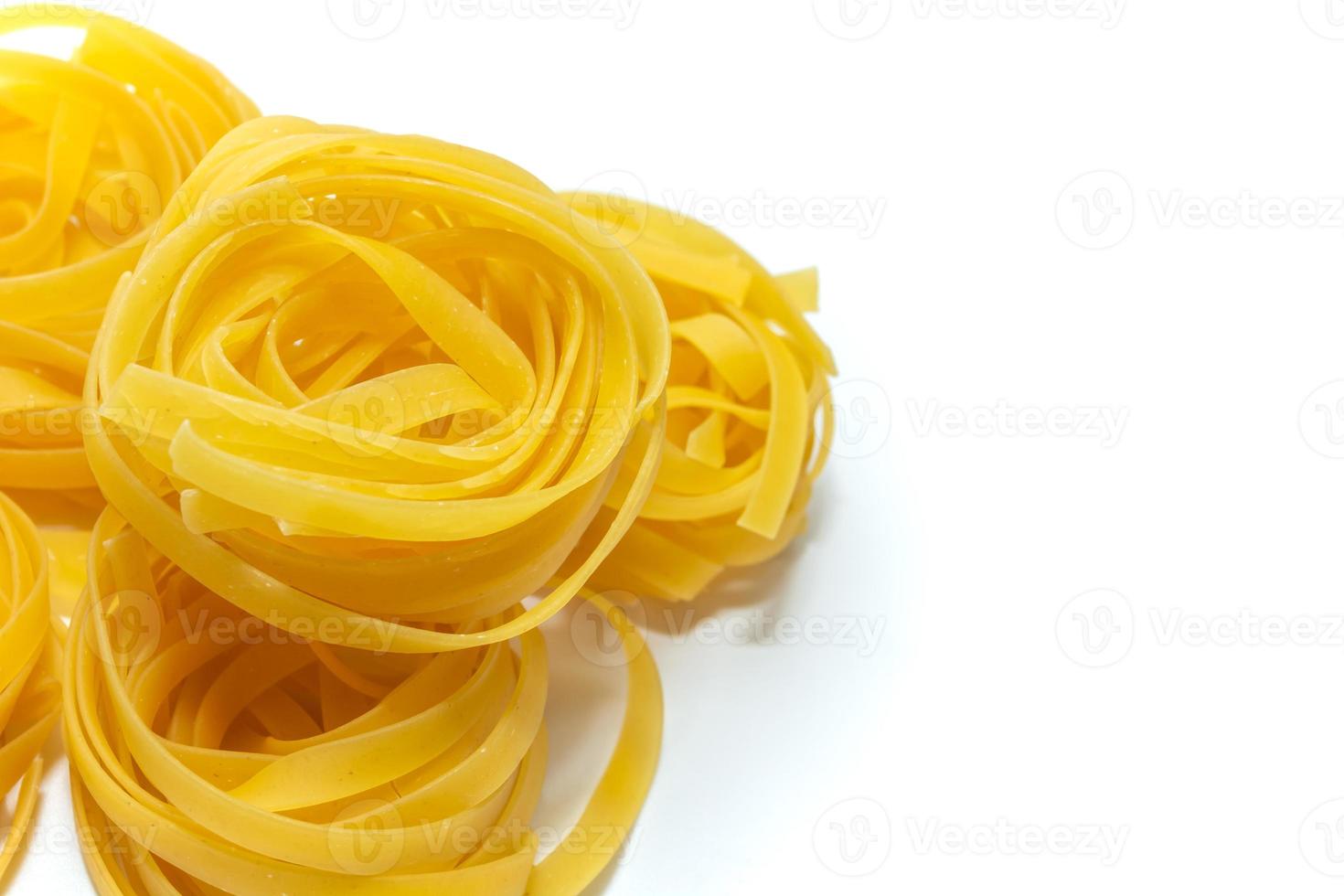 Tagliatelle. glänzende italienische Pasta aus Hartweizenmehl auf weißem Hintergrund. Nahaufnahme, Draufsicht. foto