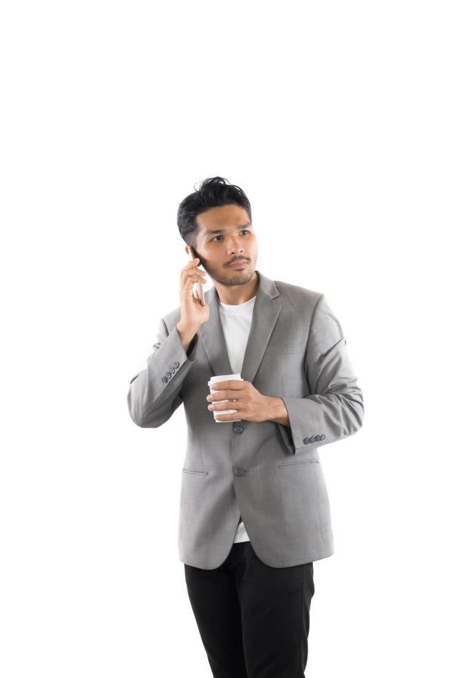 Geschäftsmannhippie, der Kaffee hält und am Telefon spricht, lokalisierte weißen Hintergrund. foto