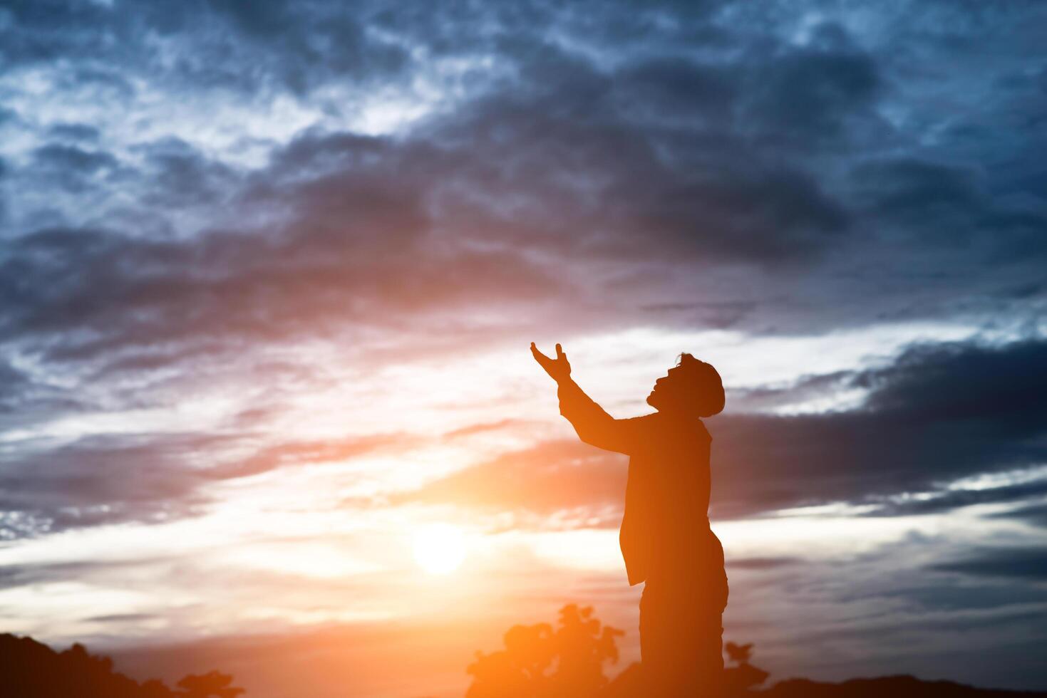 Silhouette eines gutaussehenden asiatischen Mannes, der betet. foto