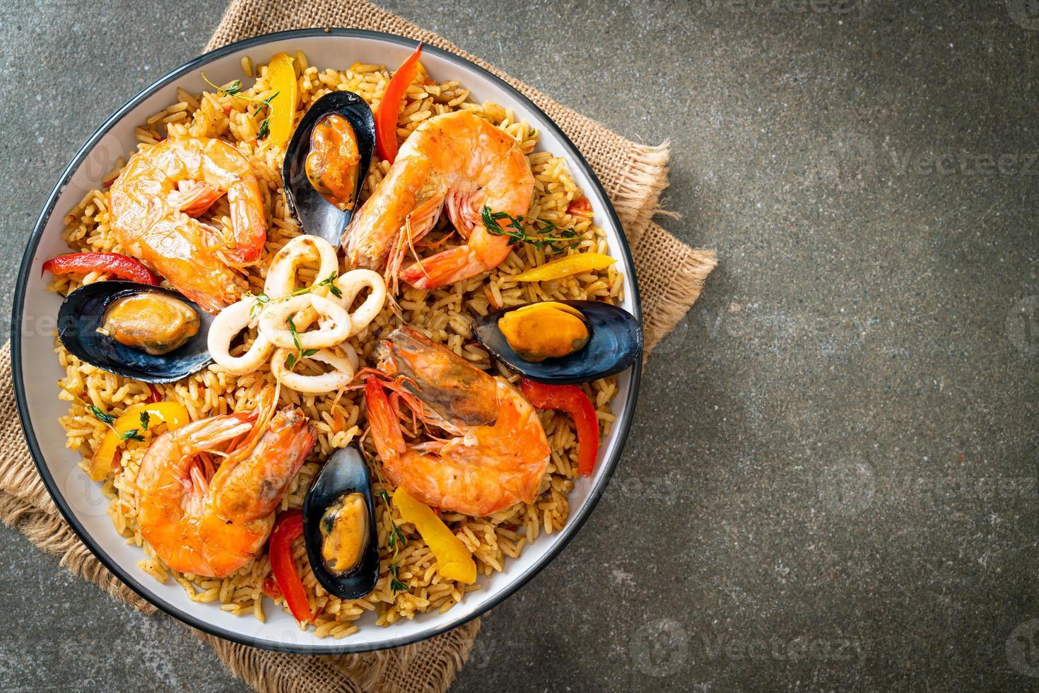 Meeresfrüchte-Paella mit Garnelen, Venusmuscheln, Miesmuscheln auf Safranreis foto