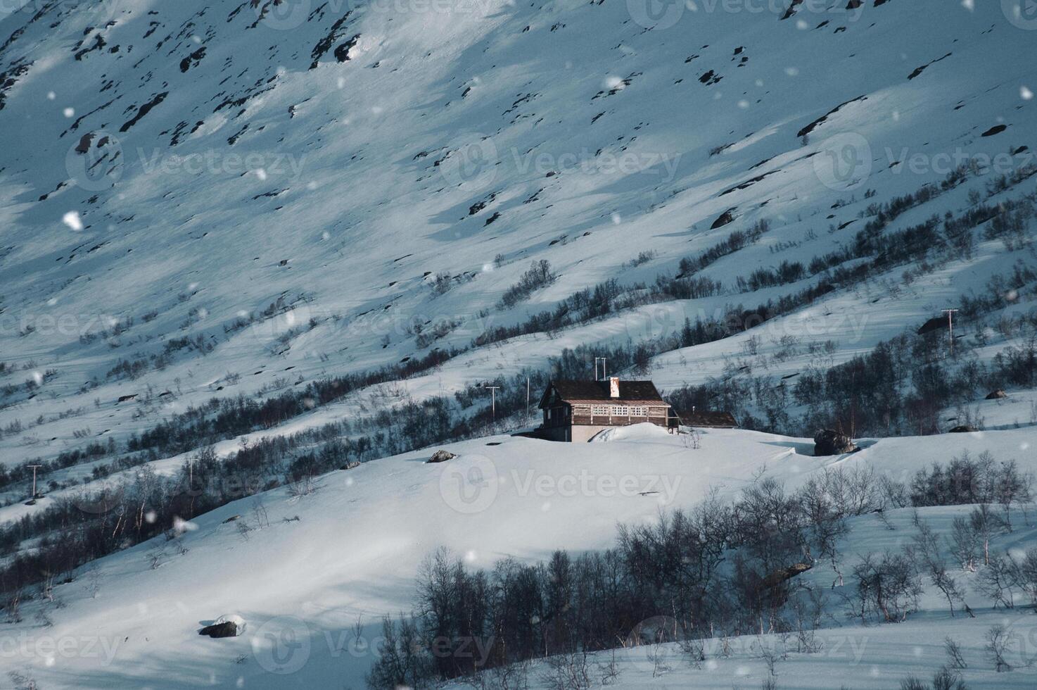 schneebedeckt Landschaft im das norwegisch hoch Berge mit ein Ski Hütte während Schneefall. foto