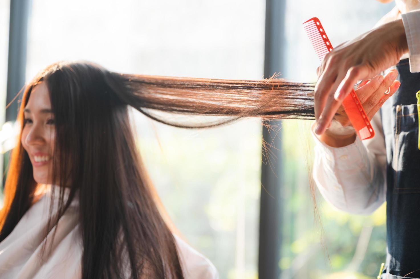 friseur und schöne kundenfrau, die behandlungshaargesundheitspflege im modestilsalon macht foto