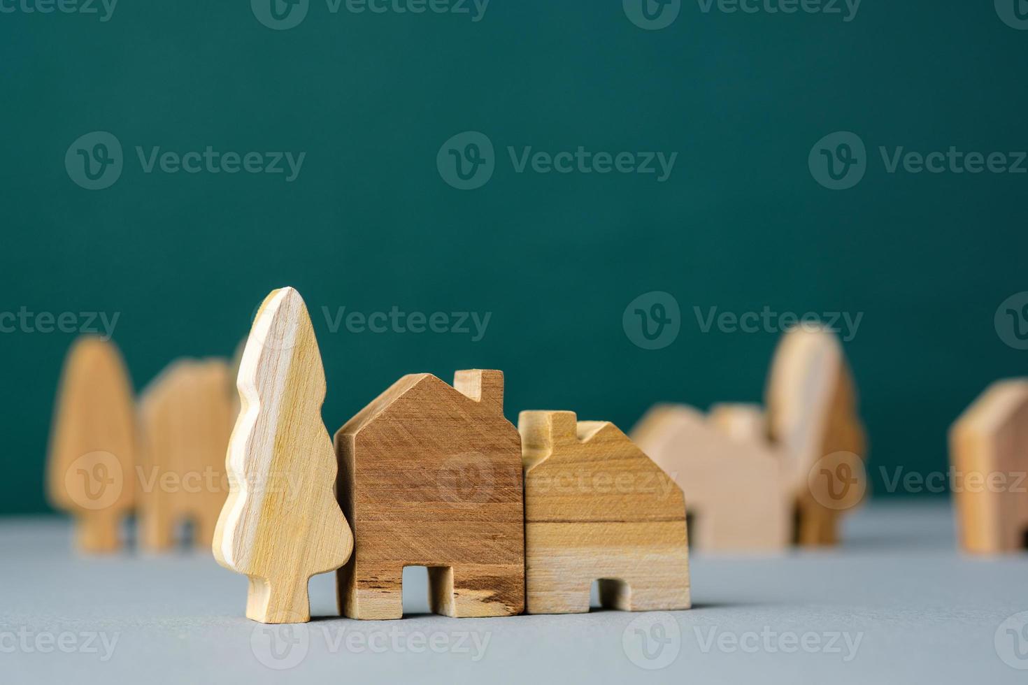 Holzhaus und Baumschmuck im Dorf auf grauem Boden und grünem Hintergrund foto