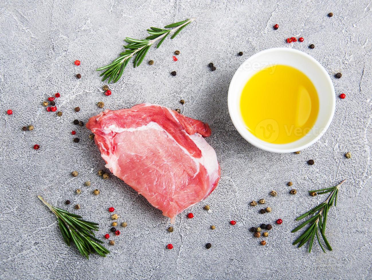 frische rohe Schweinekoteletts mit Gewürzen und Kräutern foto