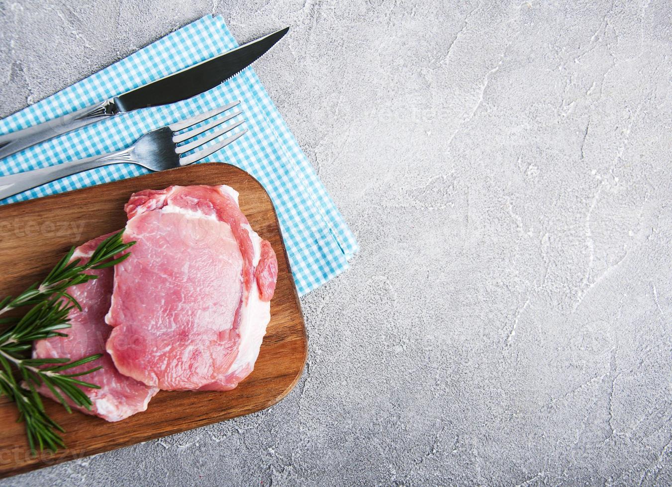 frische rohe Schweinekoteletts mit Gewürzen und Kräutern foto