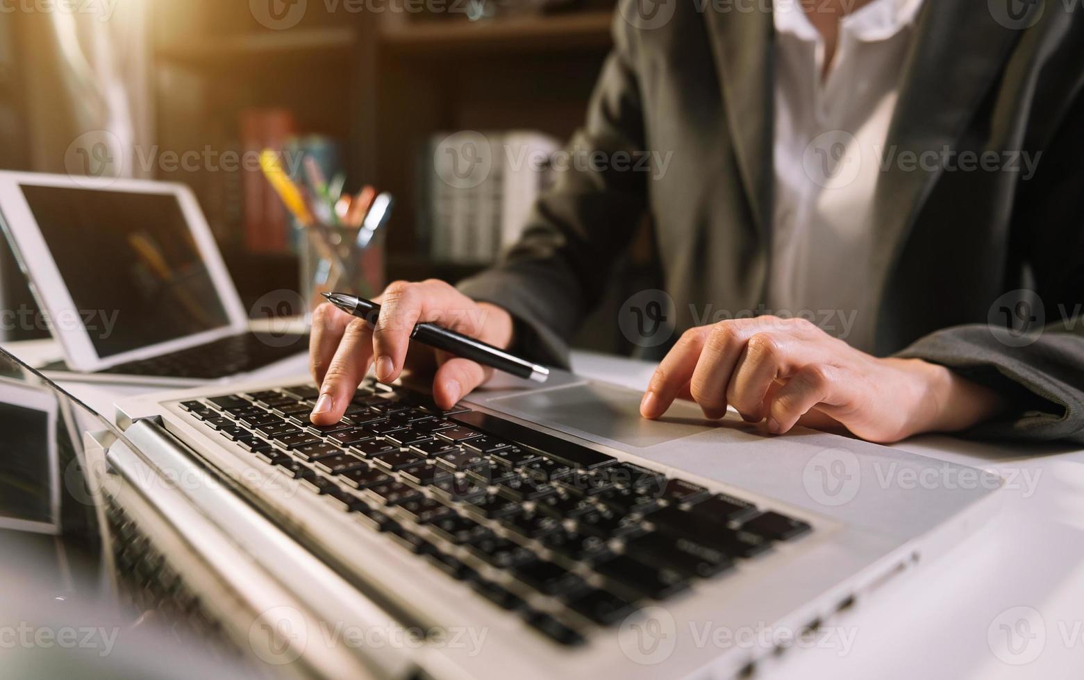 Frauen, die Münzen auf dem Taschenrechner zählen und aus dem Sparschwein nehmen. Hand, die einen Stift hält, der am Taschenrechner arbeitet, um auf dem Schreibtisch zu rechnen foto