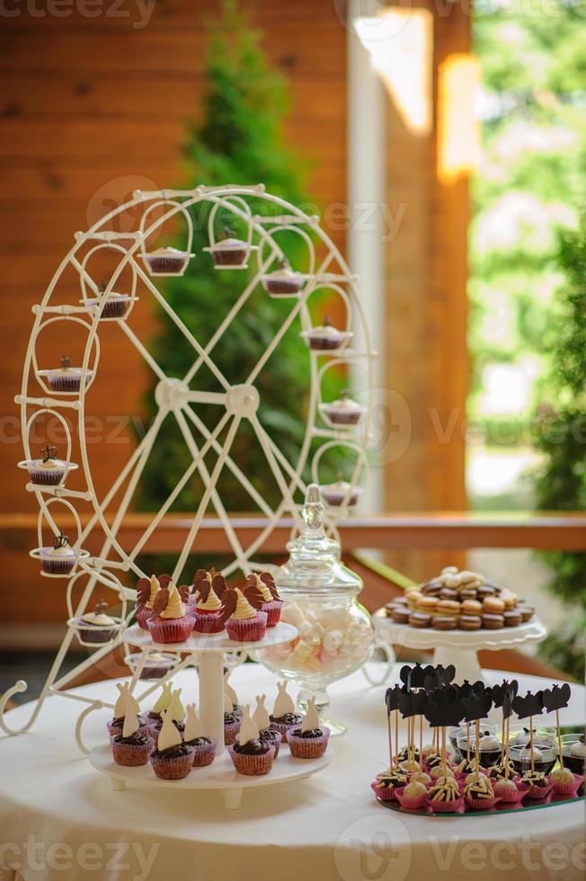 Nahaufnahme von Tablett mit viel köstlicher Vielfalt Gebäck Kuchen Törtchen und Makronen in einer Reihe. frische, bunte, bunte, grüne, gelbe, weiße und rosa süße Beerendesserts, schön dekoriert foto