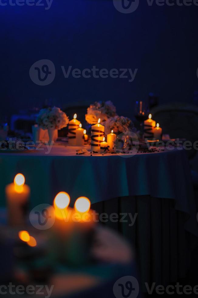 Schöner, geschmückter Tisch mit Blumenschmuck und roten Kerzen. weihnachtsabend oder hochzeitsfeier dekoration. foto