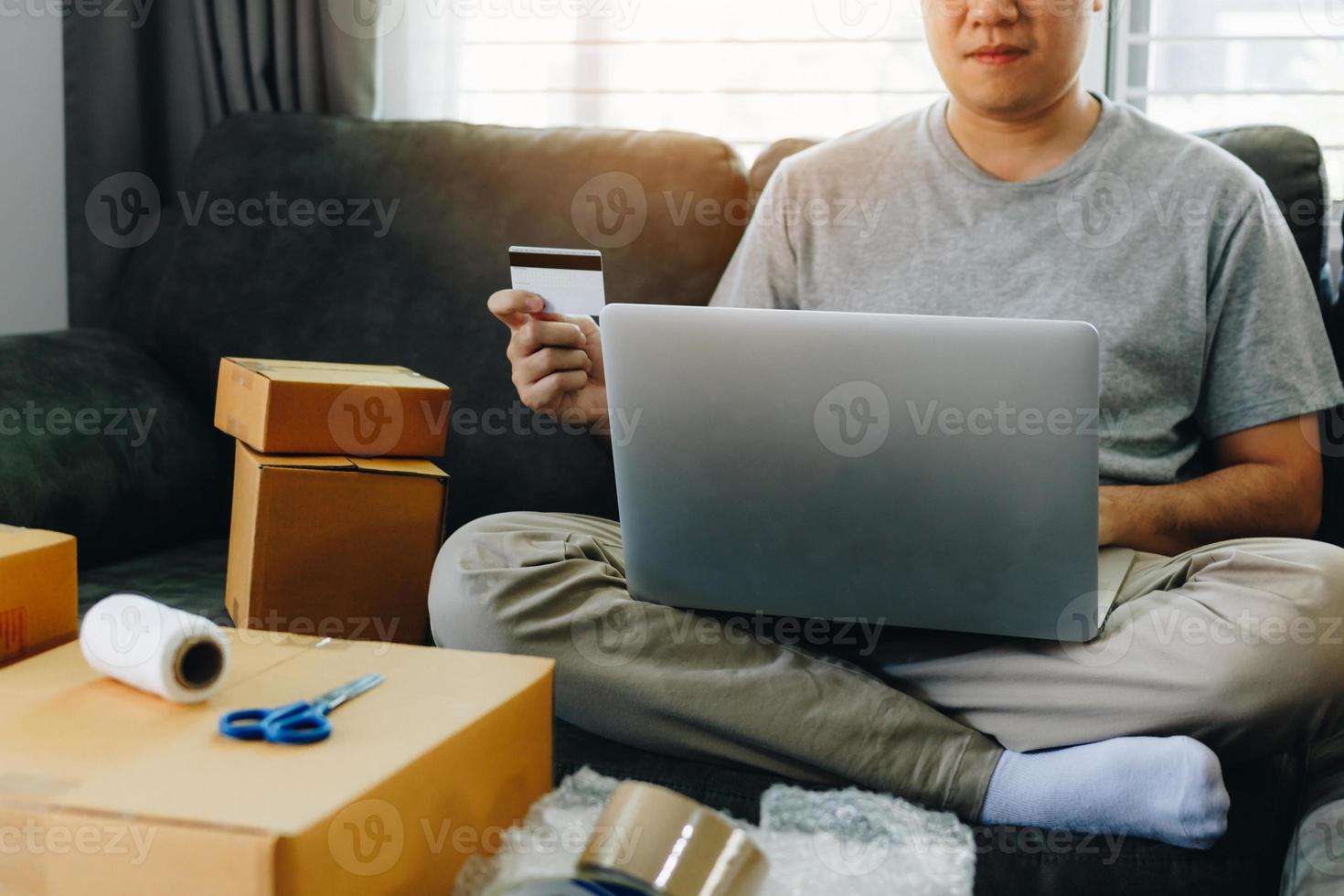 asiatischer Teenager besitzt eine Kreditkarte und verwendet ein Online-Shopping-Konzept für Laptop-Computer. foto