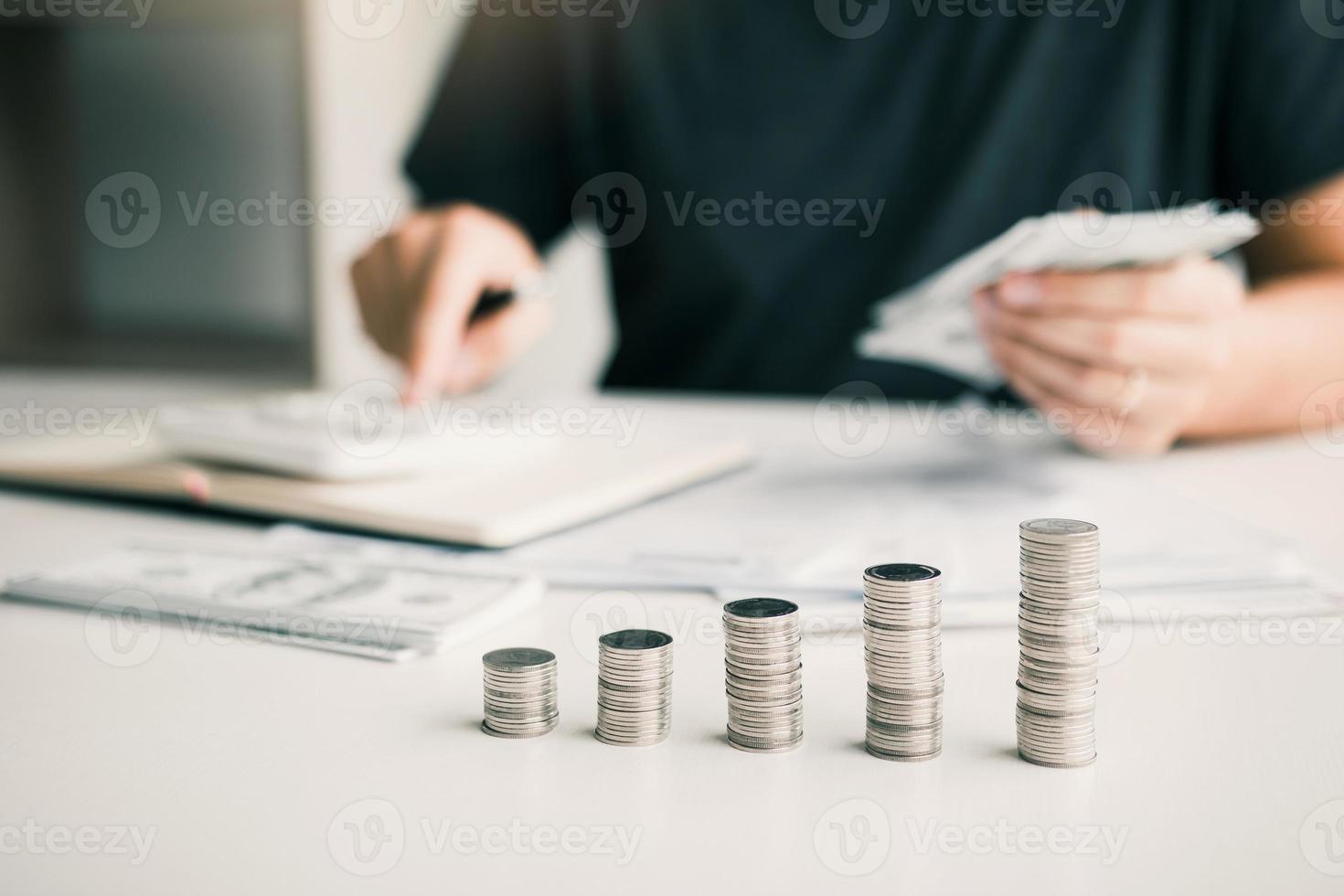 Mann benutzt Taschenrechner und Dokumente, die Spesen im Homeoffice berechnen. foto