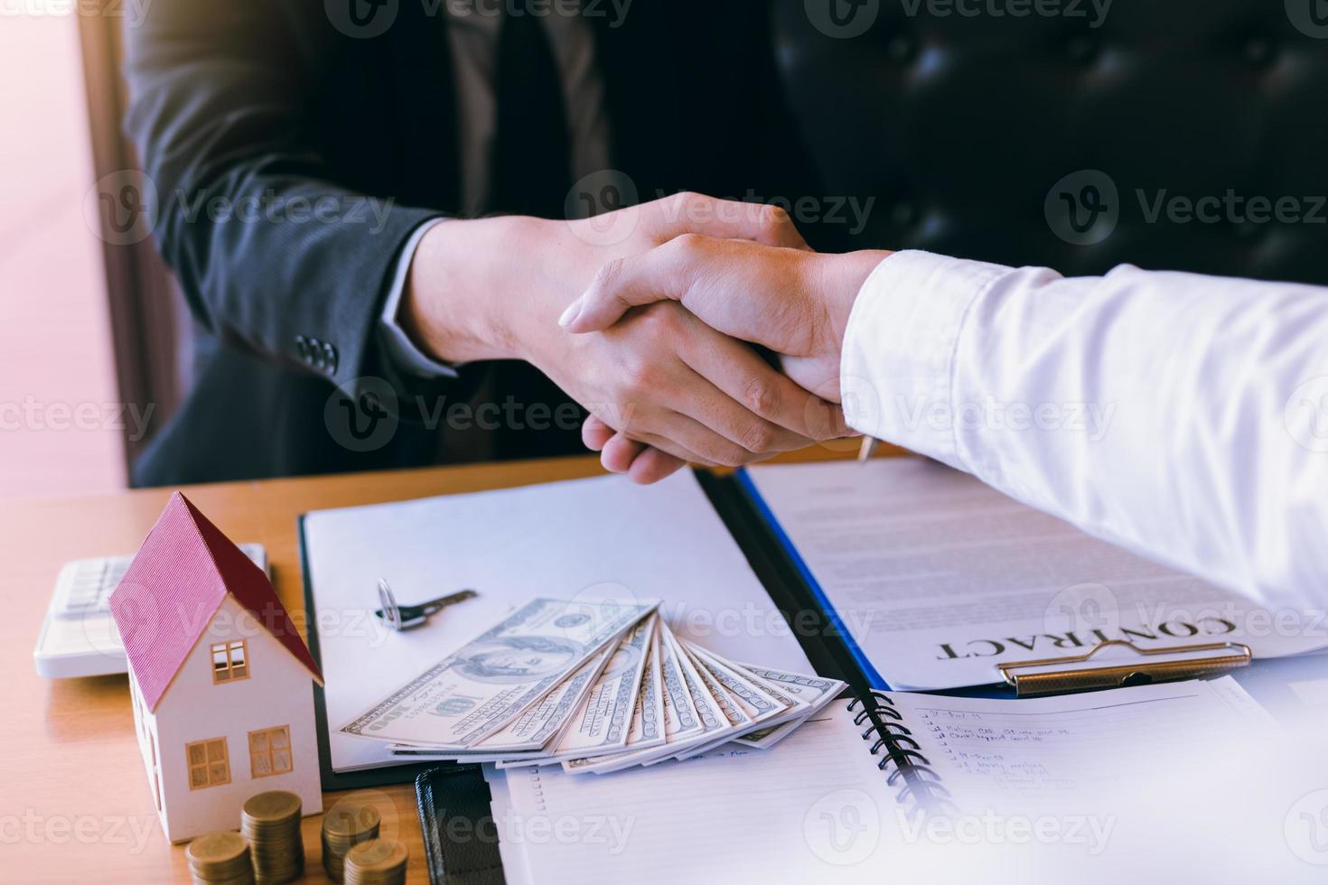 Hausverkäufer und Käufer arbeiten daran, neue Häuser zu unterzeichnen und Hände zu schütteln. foto