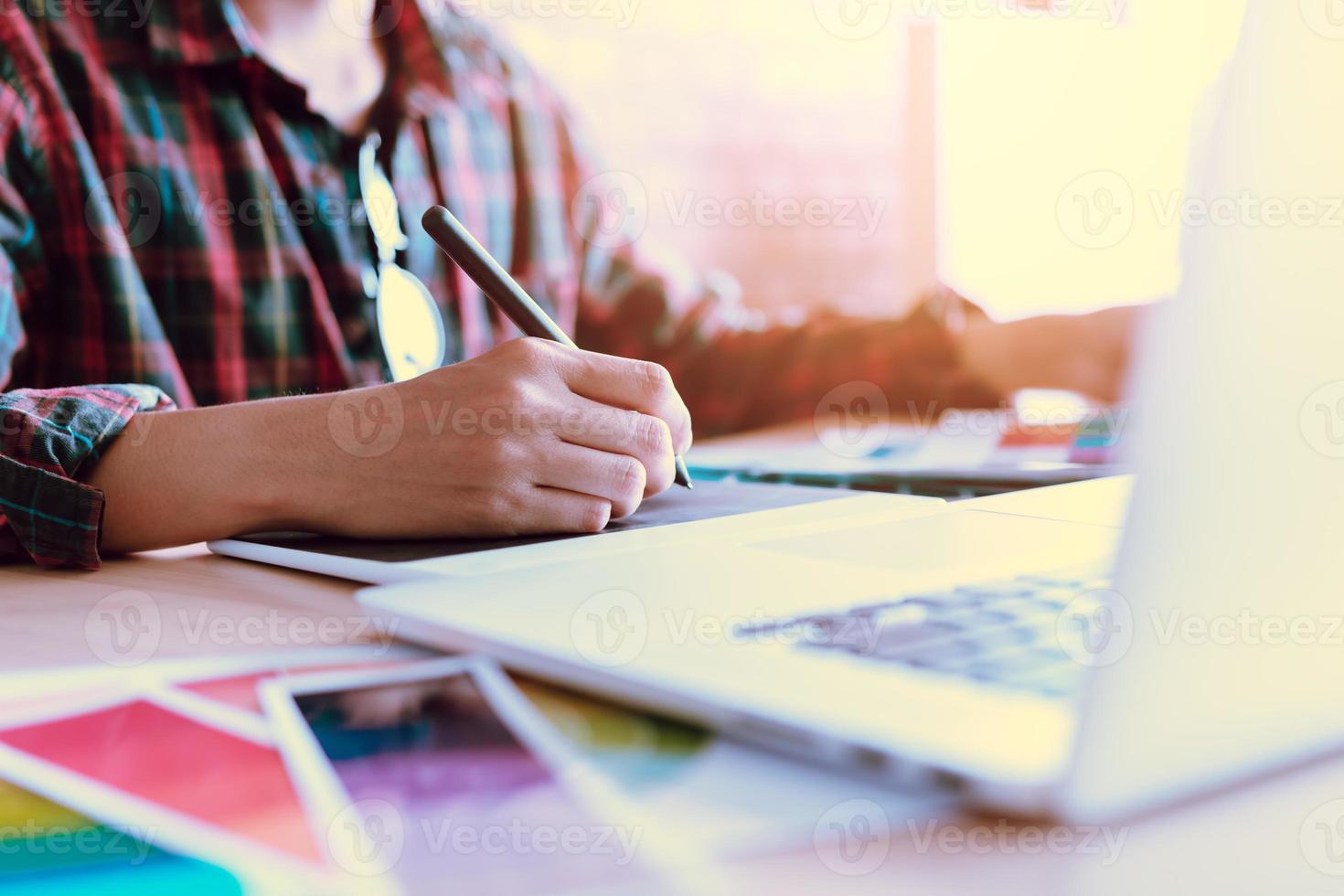 Freiberufliche kreative Designer, die mit einem digitalen Grafiktablett am Schreibtisch arbeiten und mit einem Stift im modernen Heimbüro zeichnen. foto