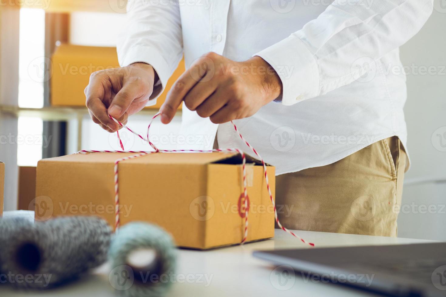 Junge asiatische Produktbesitzer im Teenageralter verpacken Produkte für kleine Unternehmen in Kartons, die für den Versand vorbereitet sind. foto