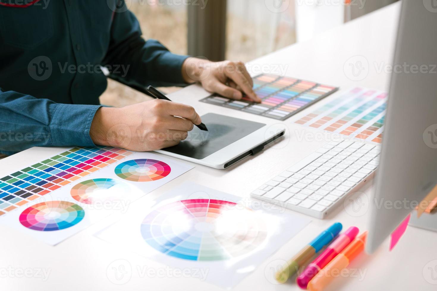 Retuscheur, der im Büroraum mit Laptop-Computer und digitalem Grafiktablett arbeitet. foto