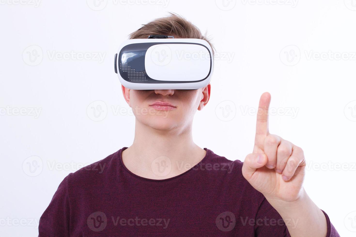 junger Mann mit Virtual-Reality-Brille und Toch-Space mit dem Finger isoliert auf weißem Hintergrund. vr-konzept und kopierraum. selektiver Fokus. leeres Schablonenhemd foto