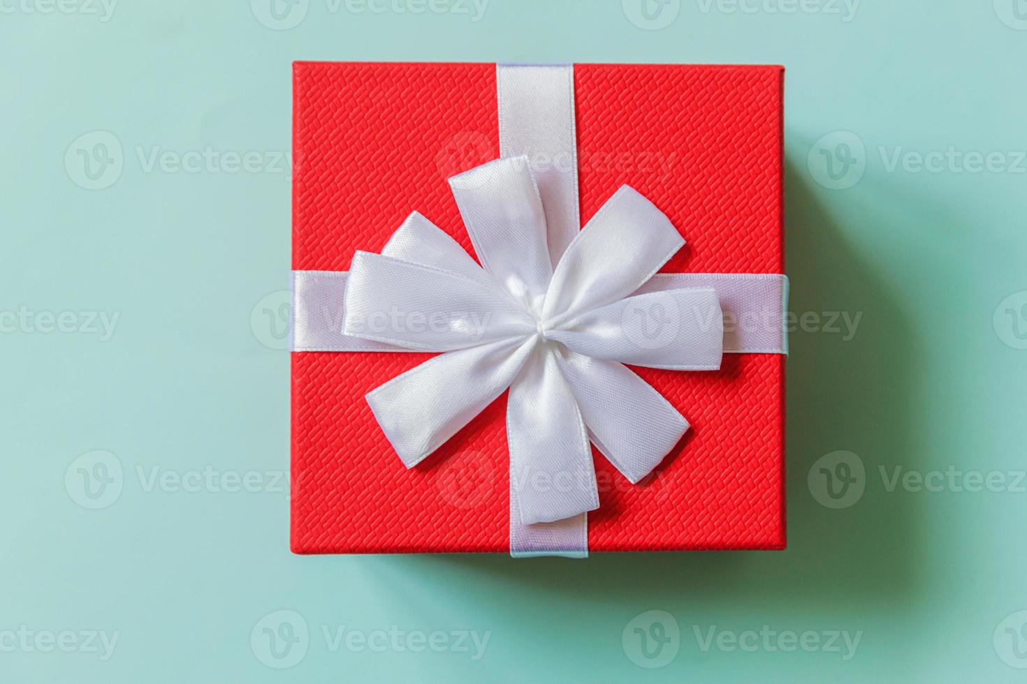 weihnachten neujahr geburtstag valentinstag feier vorhanden romantisches konzept. einfach minimalistisches Design rote Geschenkbox isoliert auf pastellblauem, farbenfrohem Hintergrund. Flache Ansicht von oben, Kopierbereich foto