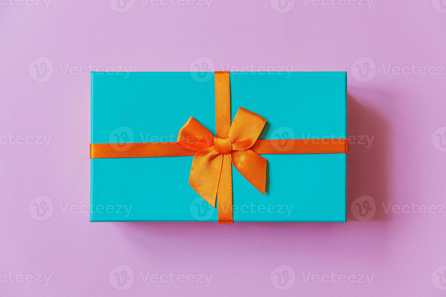 weihnachten neujahr geburtstag valentinstag feier vorhanden romantisches konzept. einfach minimalistisches Design blaue Geschenkbox isoliert auf violettem, violettem, farbenfrohem Hintergrund. Flache Ansicht von oben, Kopierbereich foto