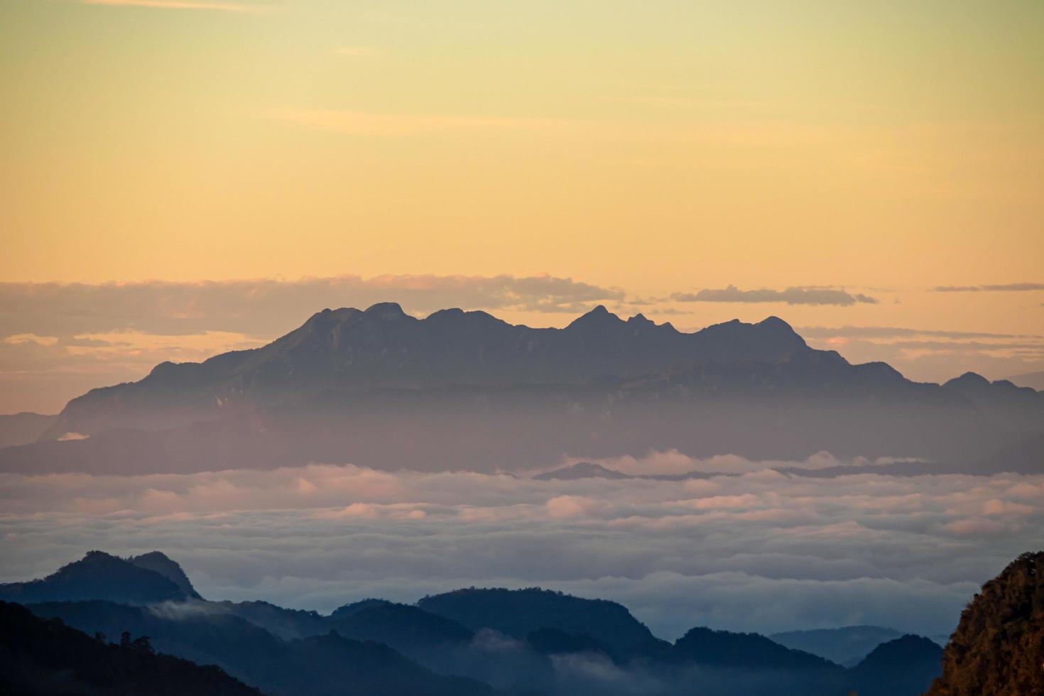 nebliger berg dramatischer sonnenaufgang hintergrund landschaft thailand foto