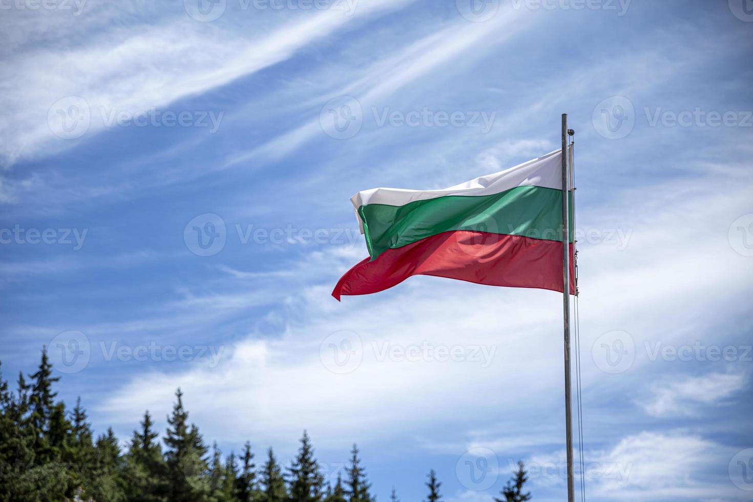 bulgarische Nationalflagge auf einer Stange gegen seidige Wolken. foto