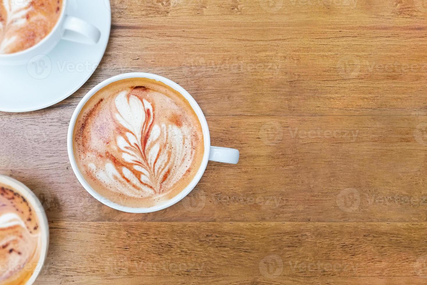 Latte-Kaffeetasse mit Kopienraum auf Holzschreibtisch foto